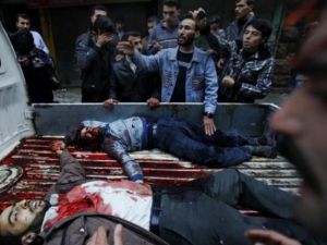 سوريون يحطيون بشاحنة صغيرة تحمل جثث مواطنيين قتلوا في قصف مدفعي على بستان القصر/أ.ف.ب