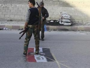 مقاتلون من المعارضة في سراقب يدوسون علما عليه صورة الرئيس السوري