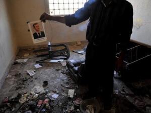 معارض يحمل صورة الرئيس السوري محترقة في المعبر الحدودي البوكمال/أ.ف.ب