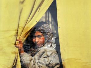 سورية تنظر من نافذة حافلة وهي مغادرة حلب/أ.ف.ب