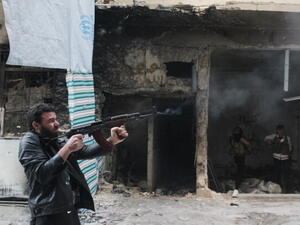 A rebel fighter from the Free Syrian Army fires his weapon during fighting against government forces on November 18, 2013. [Getty Images]