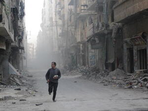 A rebel fighter from the Free Syrian Army runs in a street of Aleppo's Salah al-Din neighbourhood during fighting against Syrian government forces on November 18, 2013. [AFP]