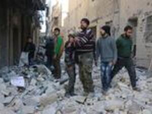 A Syrian man comforts a boy amid the rubble of buildings following a reported airstrike on the rebel-held neighborhood of al-Kalasa in Aleppo, on February 4, 2016. (AFP/Thaer Mohammed)