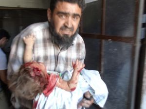 سوري يحاول اسعاف طفلته التي اصيبت خلال قصف جوي لقوات النظام في ادلب/أ.ف.ب