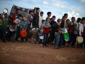 سوريون مهجرون داخل وطنهم يصطفون في طابور لتلقي مساعدات غذائية/أ.ف.ب
