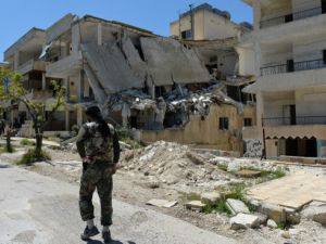 مقاتل من المعارضة يمشي وسط دمار في منطقة سملى في محافظة اللاذقية/ا.ف.ب