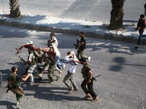 Rebel Free Syrian Army fighters drag a man suspected of being a shabiha or pro-regime militiamen on 31 July in Aleppo. [Emin Ozmen AFP/Getty Images]