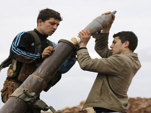 مقاتلان من المعارضة يضعون قذيفة بمدفع هاون/ أرشيفية