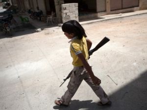 طفل يحمل سلاحا قديما يتبع لواء شهداء معرفة النعمان في معرة النعمان بحلب/أ.ف.ب