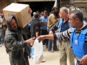 Displaced people from the Yarmouk Palestinian refugee camp queuing to receive aid from UNRWA in Yalda, south of the Syrian capital, Damascus in 2015. (AFP/File)