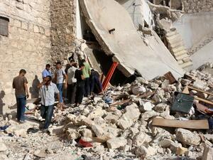 Syrians look for victims under the rubble of a collapsed building following a reported air strike on the rebel-held neighborhood of Sakhur in the northern city of Aleppo on July 19, 2016. (AFP/Thaer Mohammed)