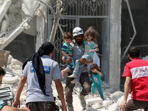 Syrian civilians and a rescue worker evacuate children in the Maadi district of eastern Aleppo after regime aircrafts reportedly dropped explosive-packed barrel bombs on August 27, 2016. (AFP/Ameer Alhalbi)