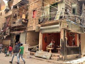 People walk past a damaged barbershop in a government-controlled district of the northern Syrian city of Aleppo on May 21, 2016. (AFP/George Ourfalian) People walk past a damaged barbershop in a government-controlled district of the northern Syrian city of Aleppo on May 21, 2016. (AFP/George Ourfalian)