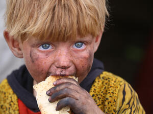 A Syrian boy eats a piece of bread in a camp for the displaced in Ain Issa, May 1 2017. (AFP/Delil Souleiman)