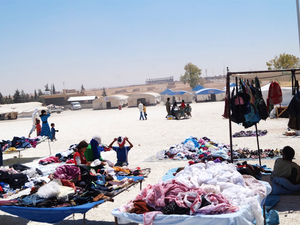 Stalls sell secondhand clothing and other items in the Ain al-Issa IDP camp. (Newsdeeply, Wladimir van Wilgenburg)