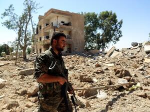 A fighter from the Syrian Democratic Forces walks in the western outskirts of Raqqa on June 27, 2017, after the area was seized from the jihadists. (Delil Souleiman/AFP)