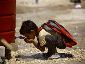 A displaced child from the Islamic State (IS) group's Syrian stronghold of Raqa, drinks water. (AFP)