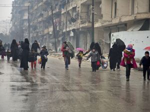 Under the hail of bullets, women and children hurry to leave one of the areas in south Damascus fought over by regimes forces and opposition groups, (AFP/ File Photo) 