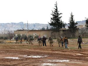 Turkey backed Syrian opposition fighters walk with their weapons in the northeastern outskirts of the Syrian town of al-Bab, Daesh's last stronghold in Syria's Aleppo's province, on February 15, 2017. (AFP/Rafat Ahmed)