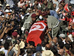 TUNISIA, Tunis : Tunisian soldiers load the coffin of assassinated opposition leader Mohamed Brahmi as his funeral procession takes place under military escort on July 27, 2013 in Tunis. AFP PHOTO / FETHI BELAID