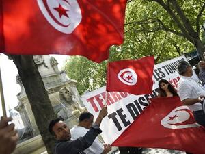 Protesters wave Tunisian flags during a demonstration against terrorism in Paris on June 27, 2015, a day after a deadly attack on a Tunisian beach resort. (Loic Venance/ AFP)