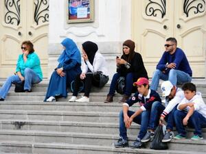 Young Tunisians sitting on the steps outside Habib Bourguiba Avenue in Tunis. (AFP/file)