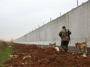  A Kurdish  fighter walks near a wall along the Syria-Turkey border at Ras al-Ain on February 2, 2016. (AFP / Delil Souleiman)
