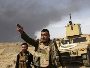 A member of Iraqi forces gestures as troops head to the frontline on October 18, 2016 near the town of Qayyarah, south of Mosul, during the operation to recapture the city from Daesh. (AFP/Bulent Kilic)