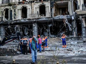 Municipal workers clean the damages caused to a hotel and the road by a bomb in the Vezneciler district of Istanbul on June 7, 2016. (AFP/Ozan Kose)