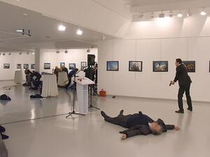 This picture taken on December 19, 2016 shows Andrey Karlov (2ndR), the Russian ambassador to Ankara, lying on the floor after being shot by a gunman (R) during an attack during a public event in Ankara. (AFP/Stringer)