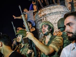 Turkish solders stay with weapons at Taksim square as people protest against the military coup in Istanbul on July 16, 2016. (AFP/Ozan Kose) Turkish solders stay with weapons at Taksim square as people protest against the military coup in Istanbul on July 16, 2016. (AFP/Ozan Kose)