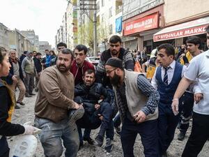 People carry an injured man near the site of an explosion at the police headquarters in Diyarbakir, southeastern Turkey, on April 11, 2017. (AFP/Ilyas Akengin)