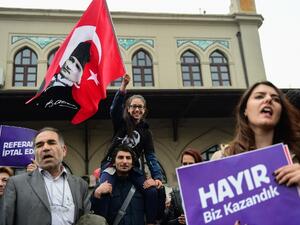 Demonstrators hold a flag of Mustafa Kemal Ataturk, founder of modern Turkey and a placard reading "No! This is just the beginning" during a protest at the Kadikoy district in Istanbul on April 23, 2017 following the results in a nationwide referendum that will hugely enhance the president Recep Erdogan powers. (AFP/Yasin Akgul)