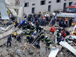 People and emergency workers are seen working at the site of a strong blast near the riot police headquarters in the center of Diyarbakir, southeastern Turkey, on April 11, 2017. (AFP/Ilyas Akengin)