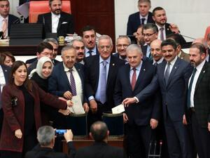 Turkish Prime Minister Binali Yildirim (3rd R) and lawmakers pose as they cast their ballots during a vote on provisions in a bill to change the constitution at the Turkish parliament in Ankara on January 14, 2017. (AFP/Adem Altan)