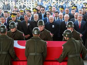 Military honour guards carry the coffin of Mahmut Uslu, one of five Turkish soldiers killed on Ferbuary 7, in an attack by IS militants around the Syrian town al-Bab, as Turkish Prime Minister Binali Yildirim (3rdR) attends the funeral ceremony in Ankara, on February 9, 2017. (AFP/Adem Altan)