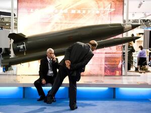 A prospective buyer inspects replica Lockheed Martin rockets at the 2013 DSEI arms fair in London. (Creative Commons)