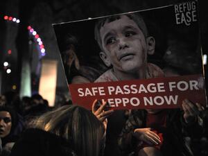 Protesters hold placards during a demonstration in solidarity with the inhabitants of the embattled Syrian city of Aleppo, outside the entrance to Downing Street, in central London on December 13, 2016. (AFP/Daniel Sorabji)