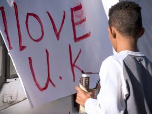 A young of immigrant origin paints the words 'I love UK' on a banner. (AFP/ File Photo)