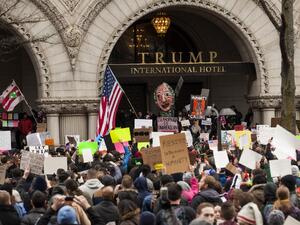  Demonstrators gather outside of the Trump Hotel International during a protest on January 29, 2017 in Washington, DC. (AFP/Zach Gibson)