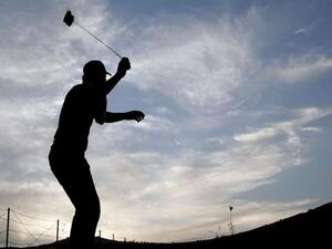 متظاهر فلسطيني يرمي جنود الاحتلال بالحجارة خلال مواجهات في نابلس بالضفة الغربية تضامنا مع غزة/أ.ف.ب