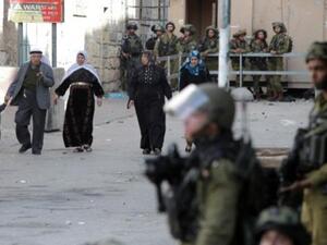 سكان من الخليل يمرون من امام قوات اسرائيلية/أ.ف.ب