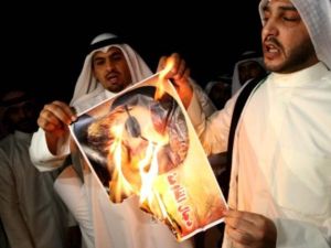 متظاهرون في الكويت يحرقون صور امين عام حزب الله حسن نصرالله احتجاجا على تدخل حزبه في سوريا/أ.ف.ب