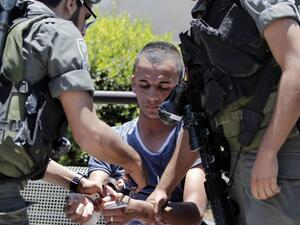 A Palestinian minor is arrested for stone throwing following clashes in Jerusalem's Old City, July 24, 2014. (AFP/File)