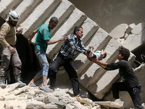 Rescue workers and volunteers save a baby from a collapsed building after airstrikes hit rebel-held areas of Aleppo in late April, 2016.  (AFP/Ameer Alhalbi)