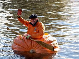 A triumphant Tom Pearcy waves from his pumpkin boat. (Screenshot)