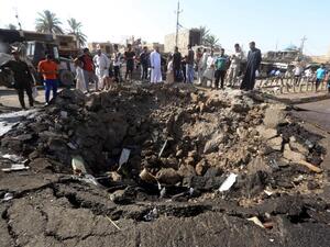 Iraqi men look at a crater on July 18, 2015 left by the car bomb attack the previous day in Khan Bani Saad, 20 km north of Baghdad. (AFP/Ahmad Al-Rubaye)

