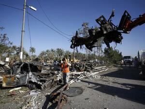 Iraqi emergency responders clear debris from the site of a truck bomb, that exploded at a crowded checkpoint, in the Iraqi city of Hilla, south of Baghdad on March 6, 2016. (AFP/Haidar Hamdani)