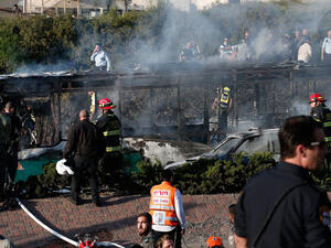 Israeli security forces and emergency services gather around a burnt-out bus following an explosion by IED (improvised explosive device). (AFP/File) 