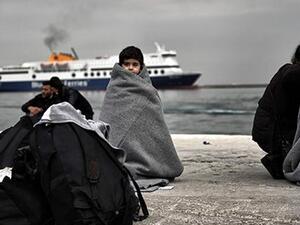 Children wrapped in covers stand in a harbour as migrants and refugees arrive on the Greek island of Lesbos while crossing the Aegean Sea from Turkey on March 2, 2016, in Mytilene. (AFP/File) Children wrapped in covers stand in a harbour as migrants and refugees arrive on the Greek island of Lesbos while crossing the Aegean Sea from Turkey on March 2, 2016, in Mytilene. (AFP/File)